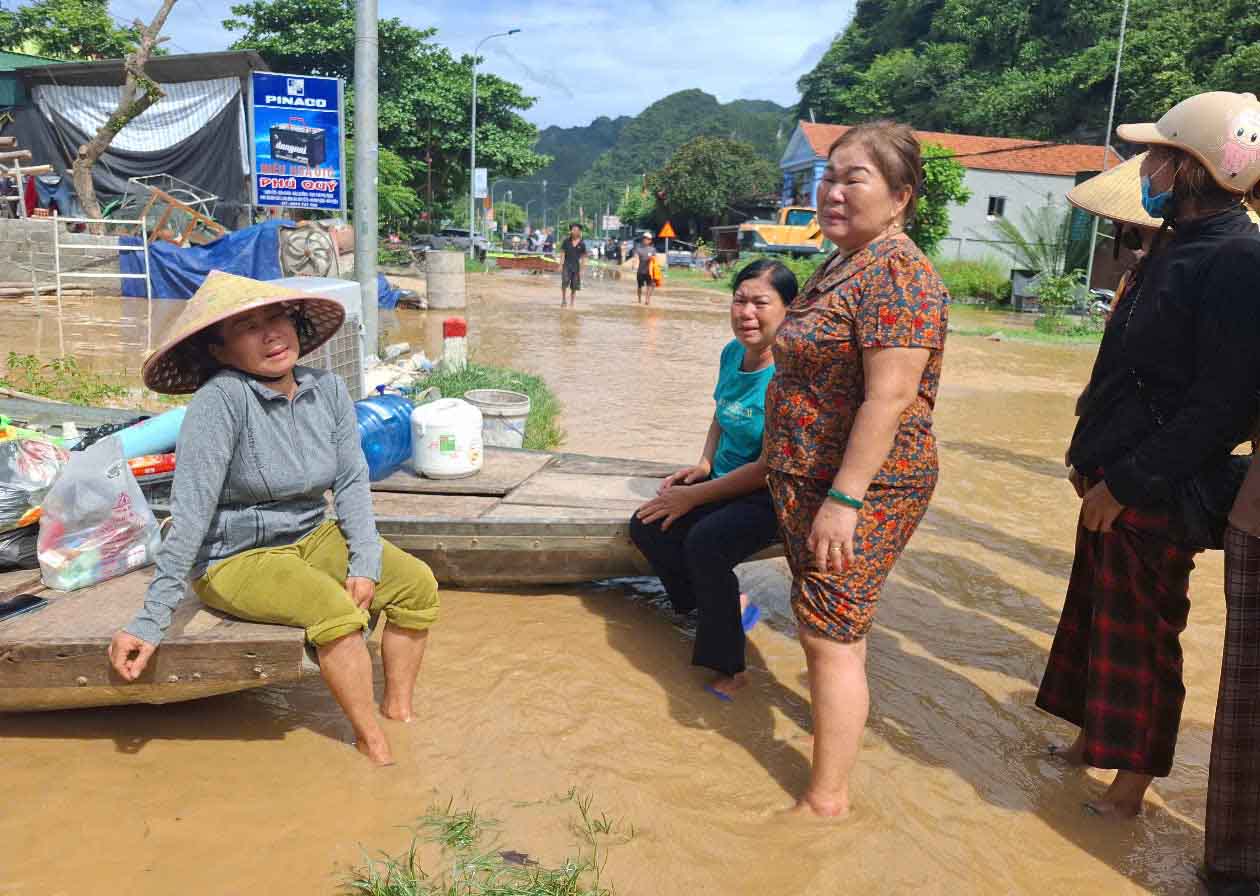 Women cried because their houses were tilted and about to flow into the river due to floods. Photo: Tran Tuan.