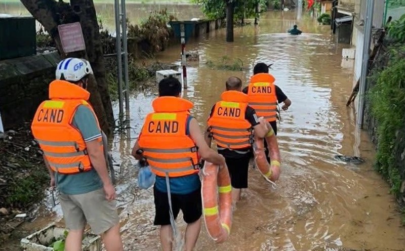 The authorities wade through water to reach the deeply flooded area, helping people evacuate to safety. Photo: Phu Tho Police