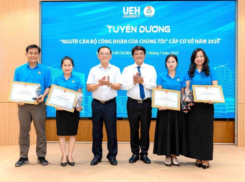 Bui Minh City Labor Federationの議長（右から3番目）およびNguyen Dong Phong教授 -  Ueh大学評議会の議長（左から3番目）は、2025年に草の根レベルで「私たちの労働組合職員」の称号を達成した個人を称賛しました。