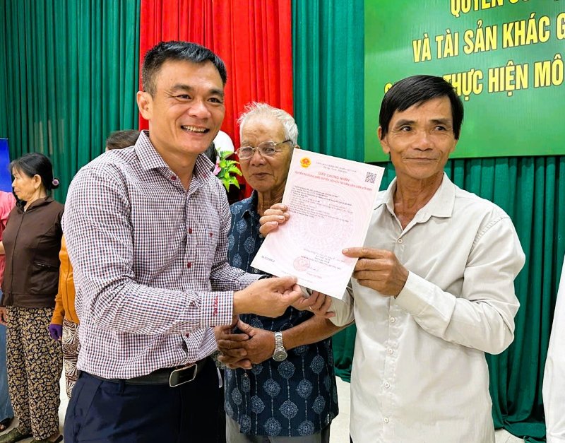 Bi thu Dang uy phuong Huong Tra, TP.Da Nang tan tay trao so do cho nguoi dan. Anh: Truong An