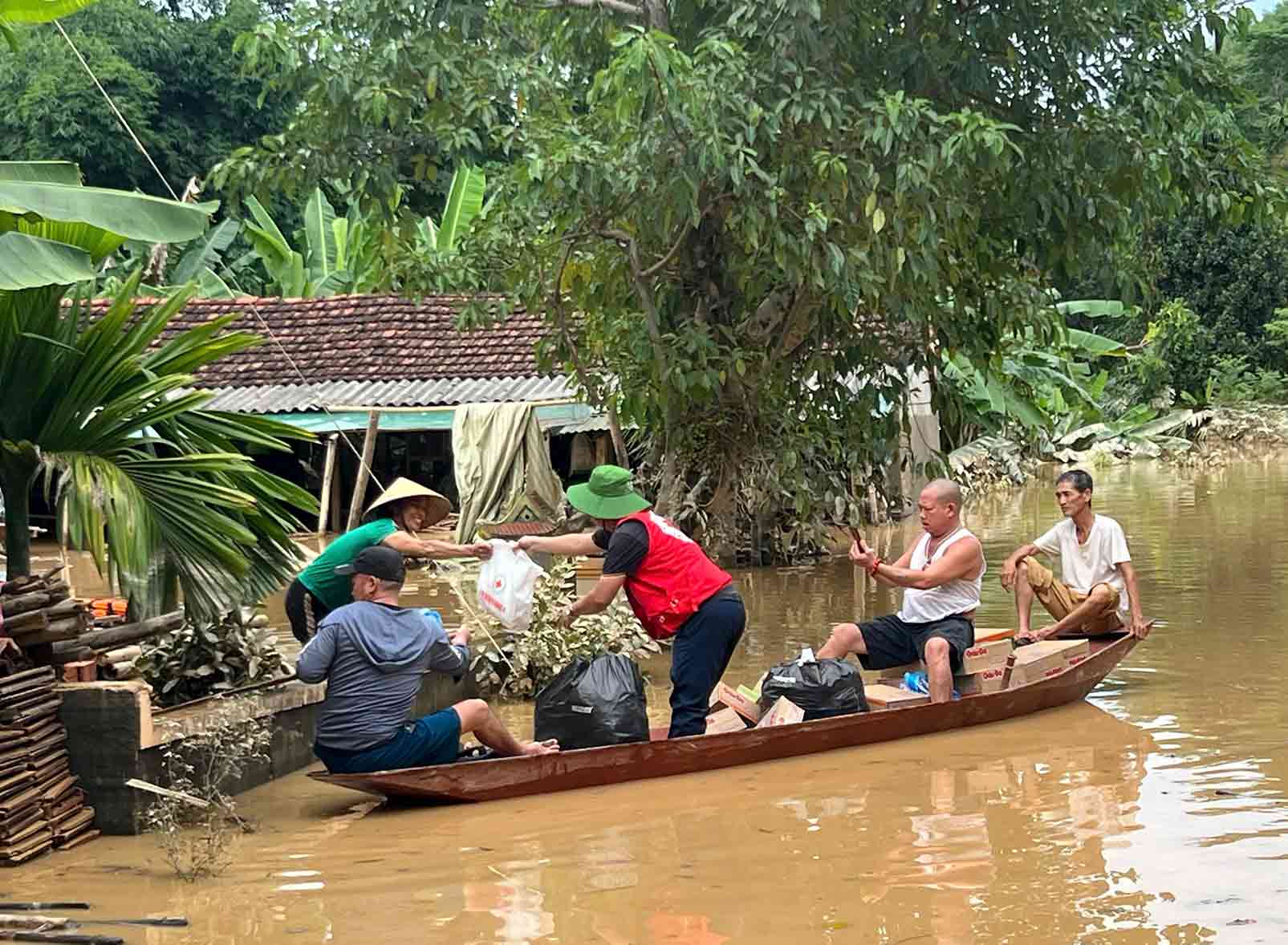Can bo Hoi Chu thap do dung thuyen de chuyen hang cuu tro den tung ho gia dinh. Anh: Hai Duong