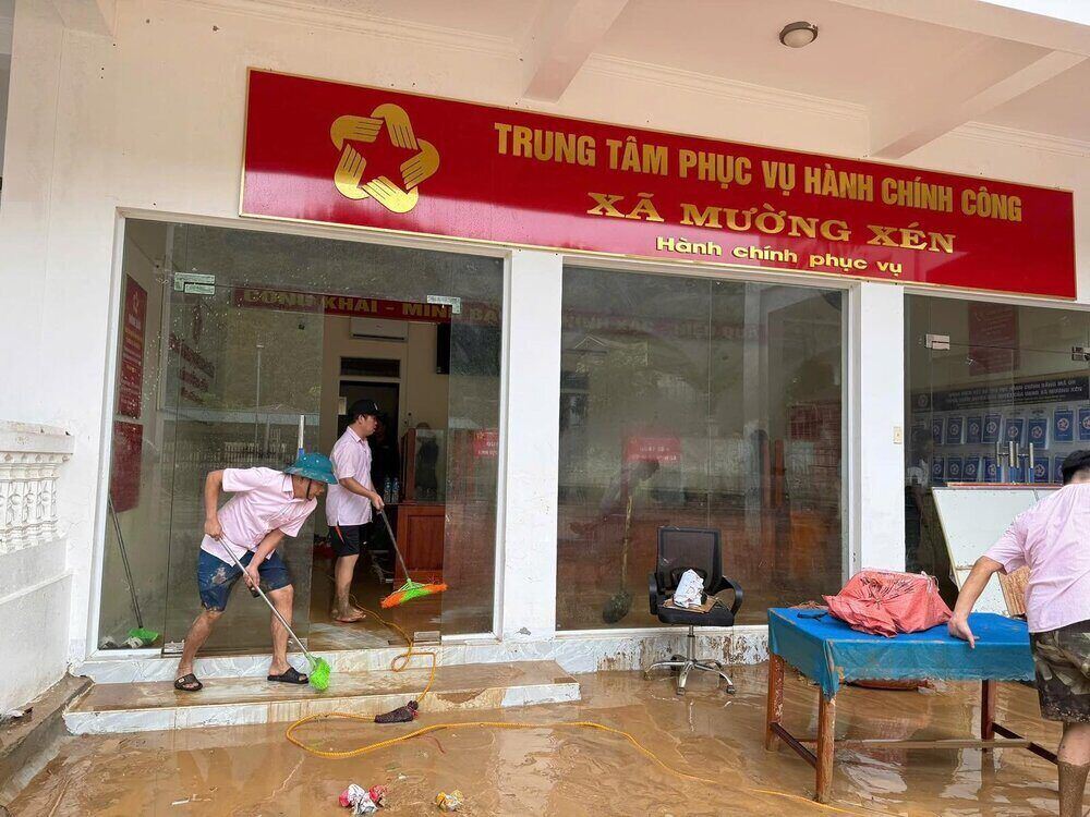 Can bo Phong giao dich NHCSXH Ky Son dong hanh cung nhan dan xa Muong Xen khac phuc hau qua lu lut. Ảnh: NHCSXH