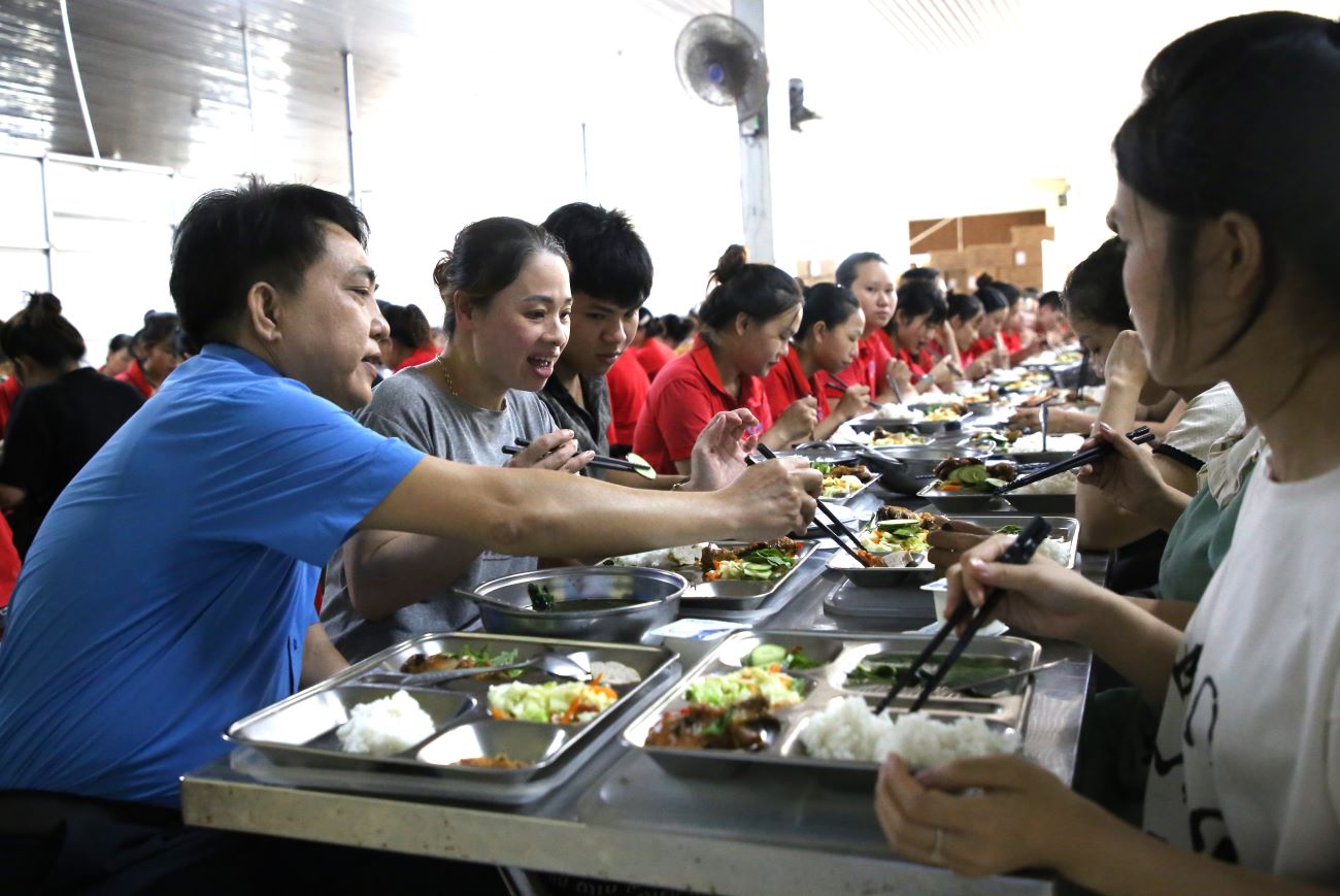 꽝찌성 노동총연맹 지도자들이 노동조합 점심 식사에 참여하고 임신 중인 여성 노동자에게 음식 일부를 양보하고 있습니다. 사진: 흥터