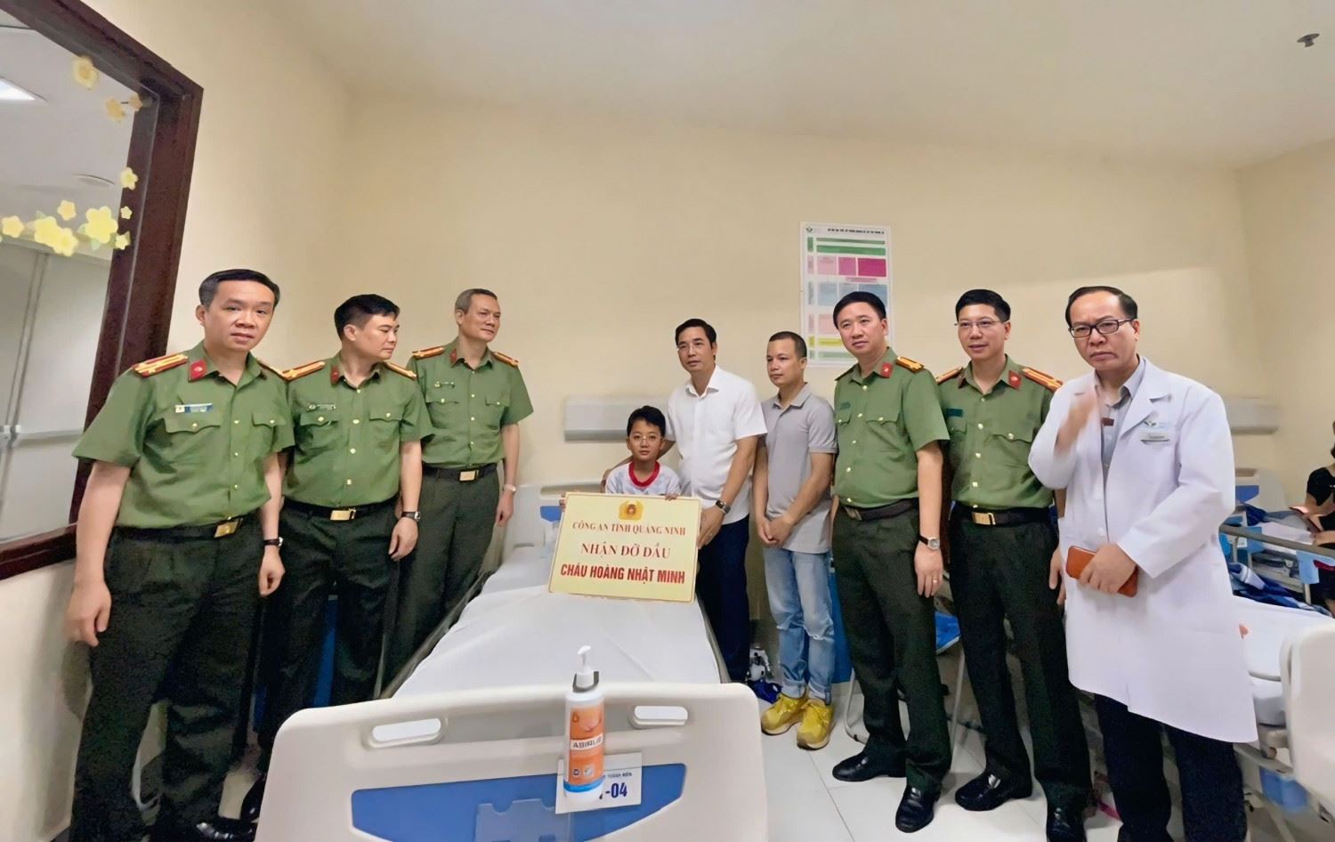 Le major general Tran Van Phuc - directeur de la police de la province de Quang Ninh (en blanc a droite a cote du bebe) - et le collectif de dirigeants des departements professionnels de la police de la province de Quang Ninh ont remis le montant de l'aide de 200 millions de dongs et ont reçu la tete de Hoang Nhat Minh - l'une des victimes chanceuses qui ont survecu a l'accident du train touristique QN-7105. Photo : Police de la province de Quang Ninh