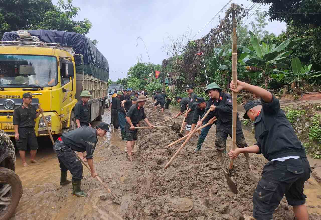 Le 25 juillet les forces de police mobiles ont participe au nettoyage de la boue dans la commune de Tam Quang (ancienne province de Tuong Duong) afin que les vehicules puissent circuler dans les deux sens apres le retrait des crues. Photo : Tran Tuan.
