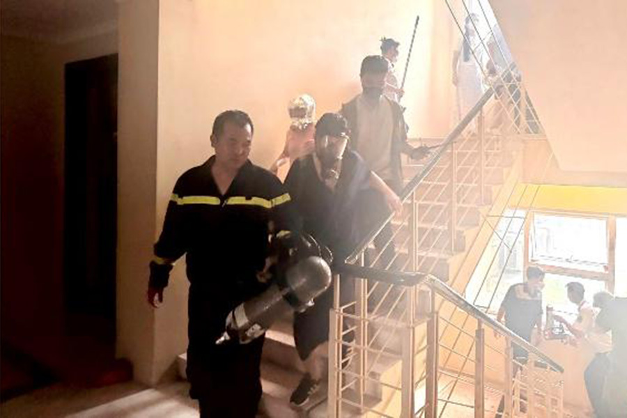 Lực lượng CC&CNCH tổ chức hướng dẫn thoát nạn và giải cứu hai người dân bị ảnh hưởng bởi khói. Ảnh: Công an Hà Nội