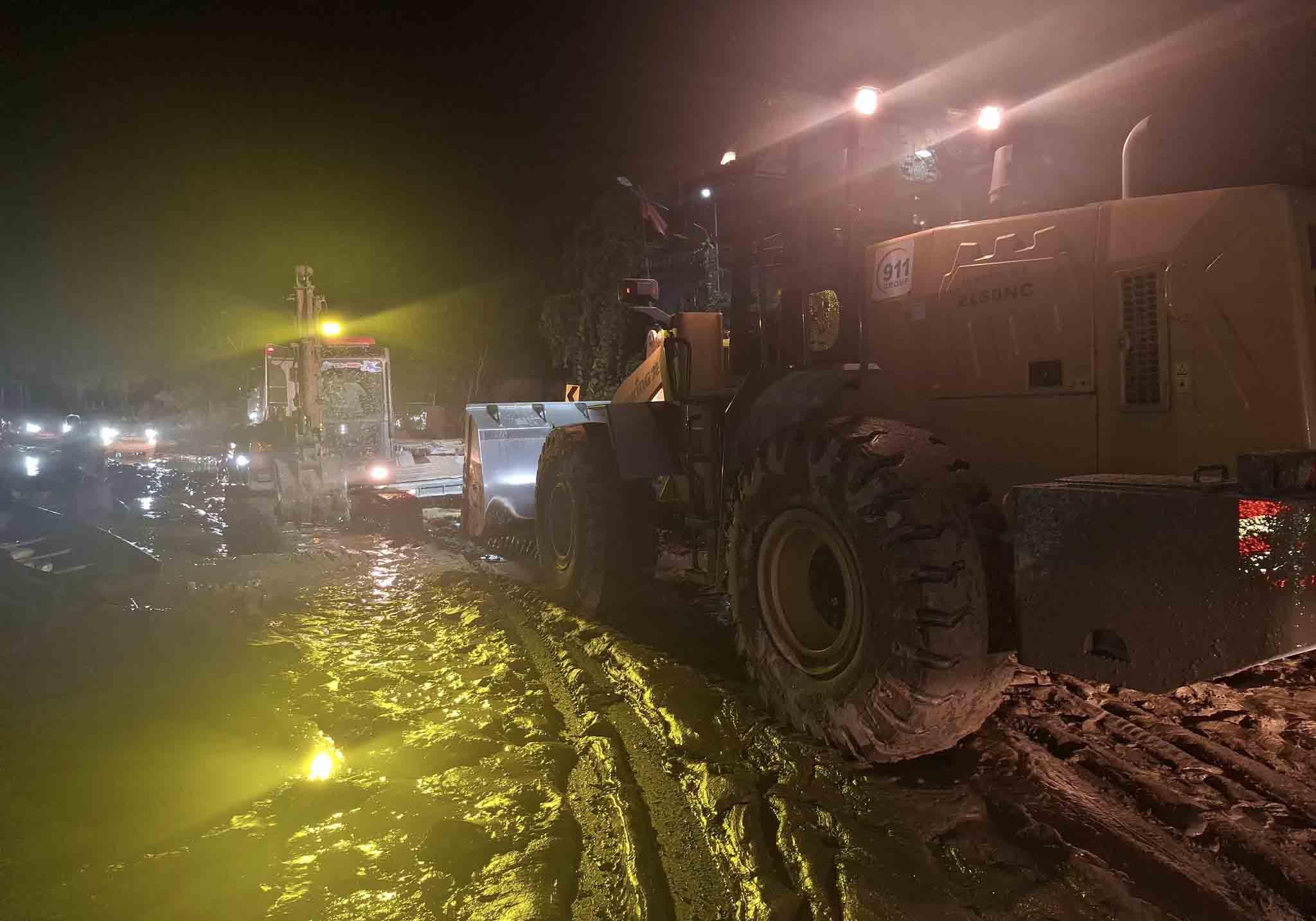Apres plusieurs jours d'efforts pour niveler la boue et le sol la route nationale 7 unique menant au poste frontiere de Nam Can traversant de nombreuses communes de l'ouest de Nghe An a ete ouverte a 22h26 dans la nuit du 25 juillet. Photo : Tran Tuan.