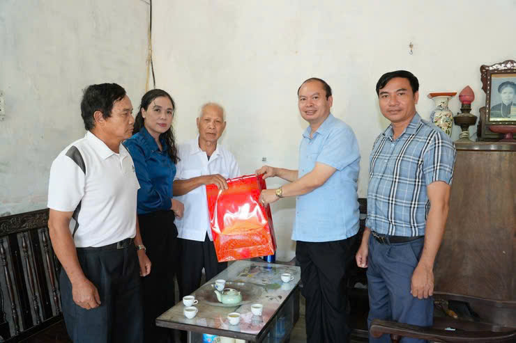 Chu tich UBND xa Chuyen My Nguyen Huu Chi (ao xanh, thu hai tu phai) tham hoi gia dinh chinh sach. Anh QT