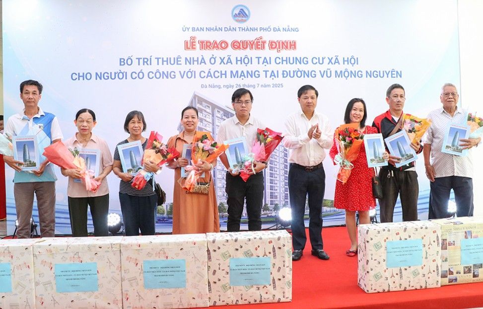 Chu tich UBND thanh pho Luong Nguyen Minh Triet (thu 4, ben phai sang) trao quyet dinh cho thue can ho chung cu va tang qua cho cac ho nguoi co cong cach mang. Anh: Truong An