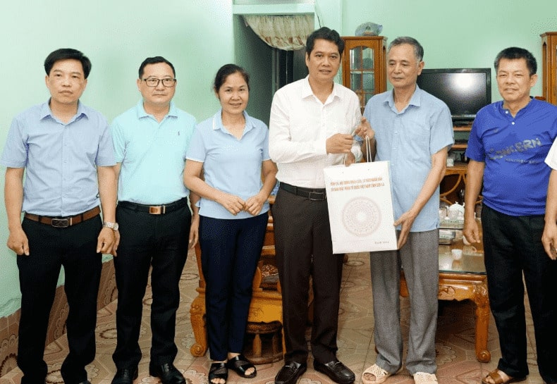 Sr. Vi Duc Tho - Presidente del Comite del Frente de la Patria de Vietnam de la Provincia de Son La (Camisa Blanca) dio regalos a la enferma Nguyen Van Lang, en Sub -Areea 2, Phu Yen Commune. Foto: Minh Nguyen