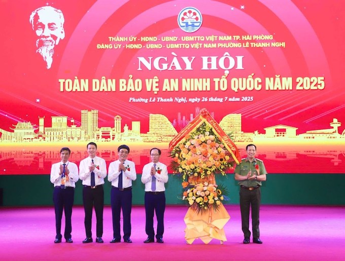 Thuong tuong Le Van Tuyen - Thu truong Bo Cong an tang hoa chuc mung Nhan dan va can bo phuong Le Thanh Nghi. Anh: Cong an TP Hai Phong  