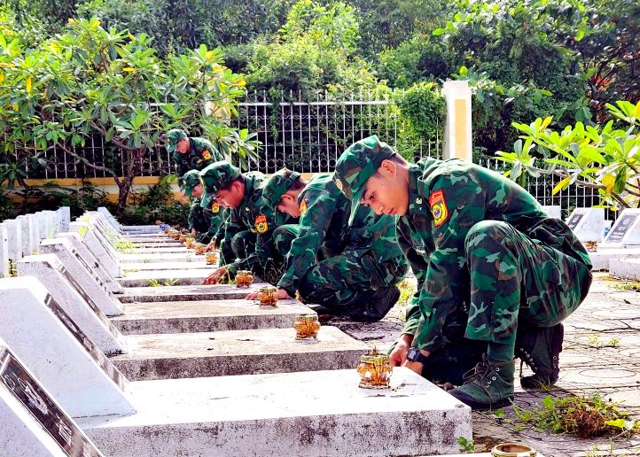 Can bo, chien si Don Bien phong Cua khau quoc te Ha Tien lam ve sinh cac mo liet si. Anh: La Nguyen