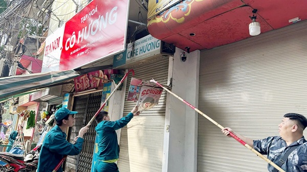 Les forces de l'ordre demantelent les panneaux violant l'ordre urbain. Photo : Bao Tam