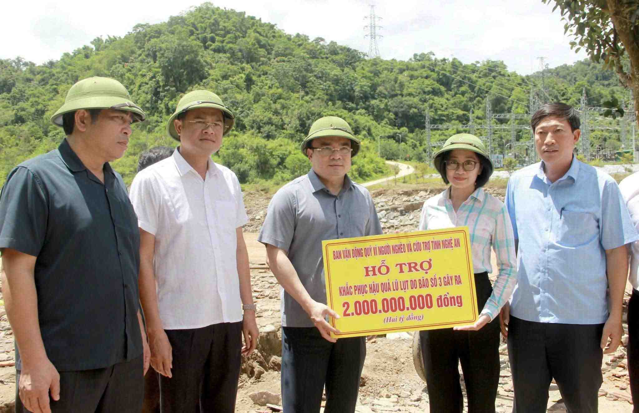 Le vice-president du Comite populaire provincial de Nghe An Phung Thanh Vinh et la delegation de travail remettent un soutien de 2 milliards de dongs pour remedier aux consequences des inondations. Photo : Ngoc Anh