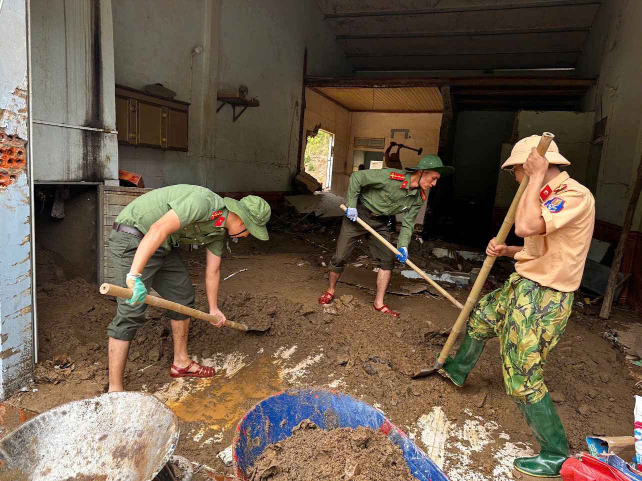 Can bo chien si Cong an Nghe An giup dan don dep nha cua sau mua lu. Anh: Ngoc Anh