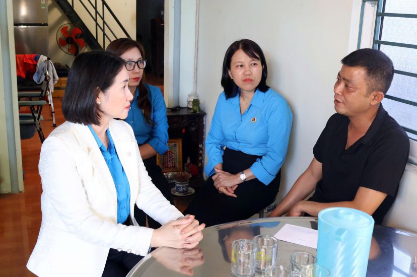 Ba Nguyen Thi Anh Lan - Chu tich Lien doan Lao dong tinh Quang Ngai (ngoai cung ben trai) tham, tang qua doan vien bi tai nan lao dong. Anh: Quoc Chinh