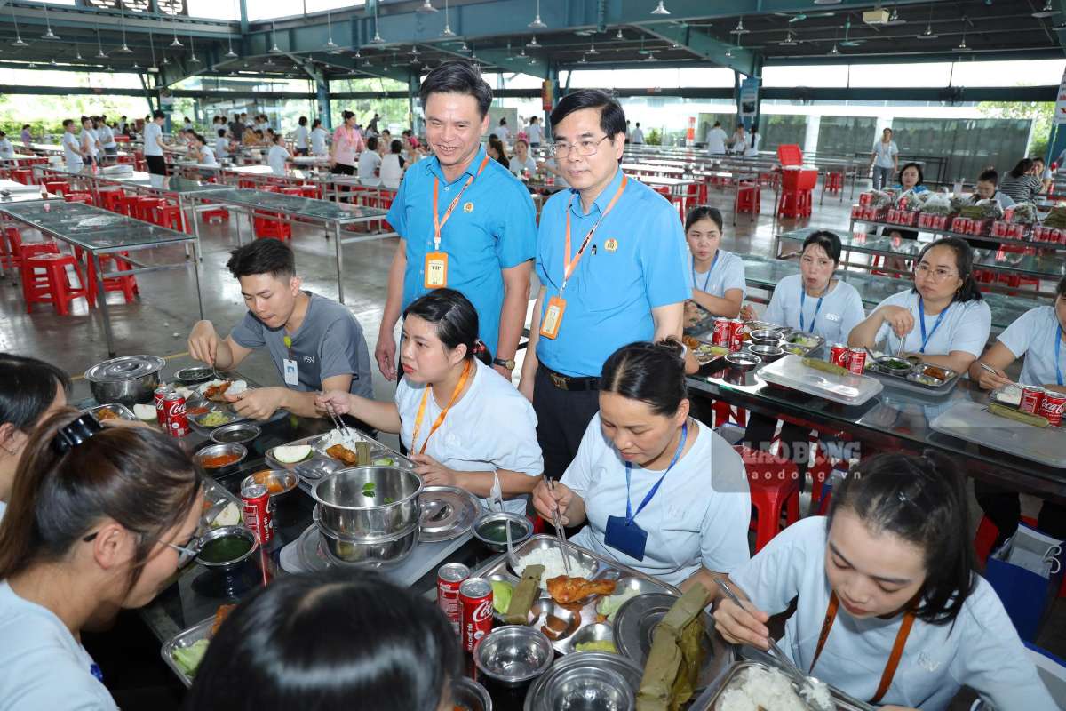 닌빈성 노동총연맹 지도부가 1955 노동조합 점심 식사 자리에서 노동자들에게 안부를 묻고 격려하고 있습니다. 사진: 르엉 하