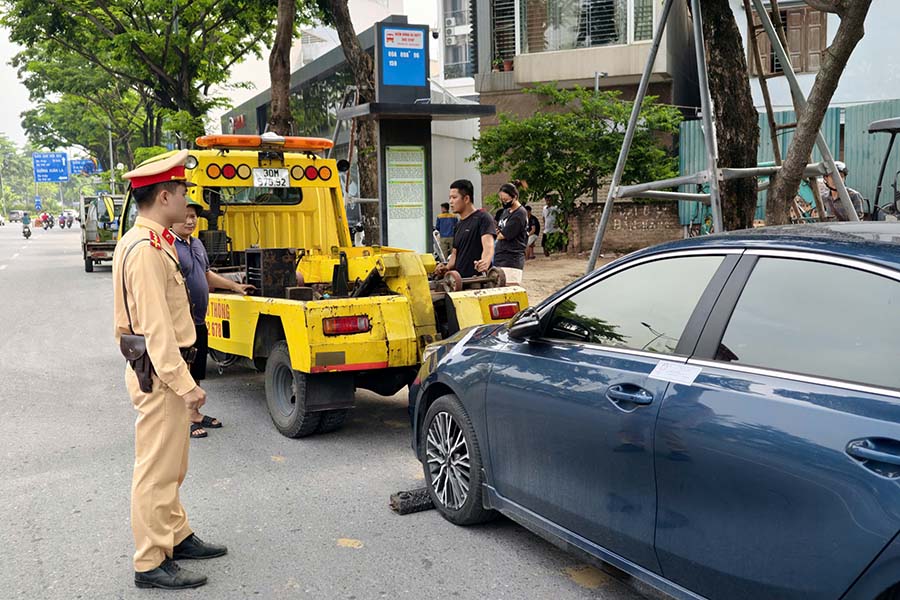Xe ôtô dừng đỗ sai quy định, cảnh sát đã liên hệ và chờ quá 30 phút nhưng tài xế không ra làm việc. Do đó, lực lượng chức năng lập biên bản, đưa phương tiện về trụ sở để giải quyết theo quy định. Ảnh: Tiến Trạch