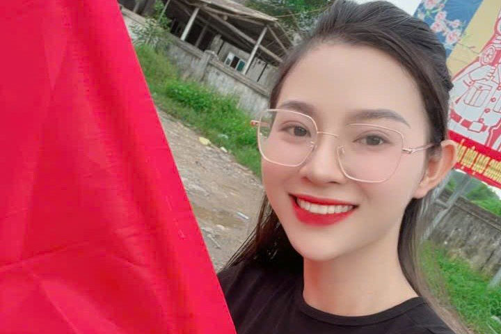 Una hermosa chica sostiene una bandera roja con una estrella dorada invitando a grupos de caridad a cenar gratis en la comuna de Anh Son Nghe An. Foto: Ngoc Anh