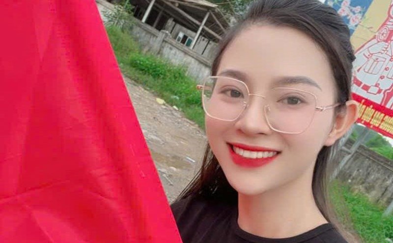The beautiful girl holding a red flag with a yellow star invited volunteer groups to eat free meals in Anh Son commune, Nghe An. Photo: Ngoc Anh