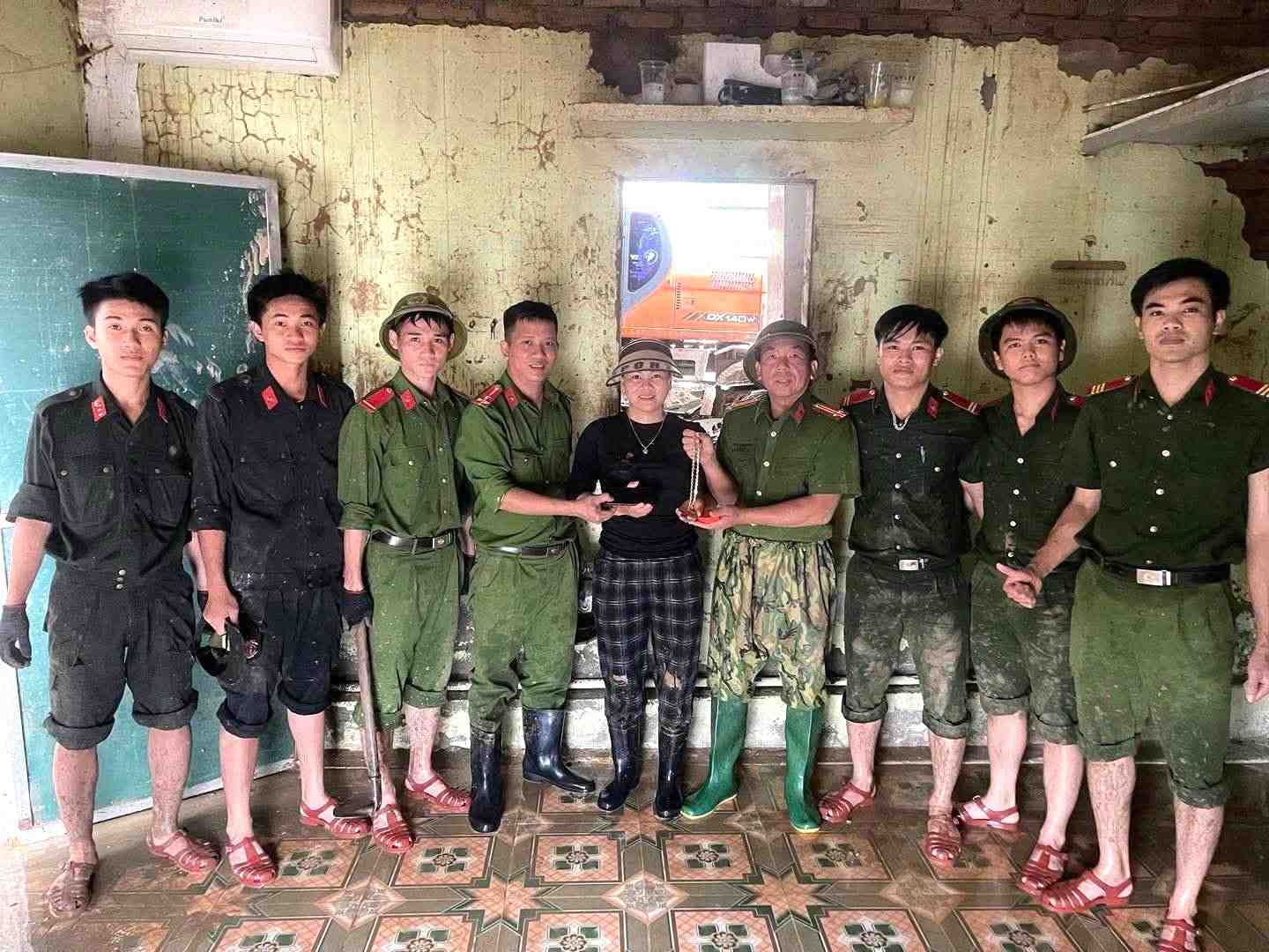 Nguyen Thi Tan 여사는 응에안 공안으로부터 깊은 진흙층에 묻힌 금목걸이와 휴대폰을 인계받고 기뻐하고 있습니다. 사진: Ngoc Anh