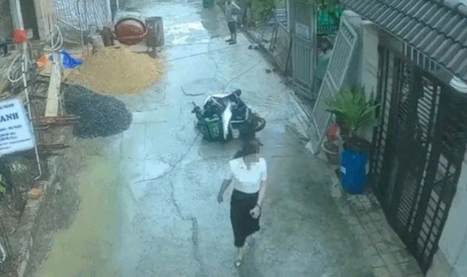 The woman pushed the shipper's motorbike down in the alley. Photo cut from clip