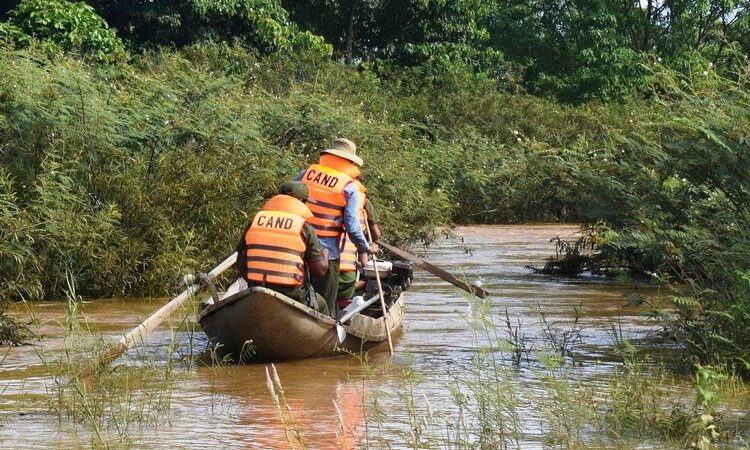 La police de la commune de Son Ha province de Quang Ngai et les habitants locaux organisent la recherche des personnes disparues le long des deux rives de la riviere. Photo : Duc Minh