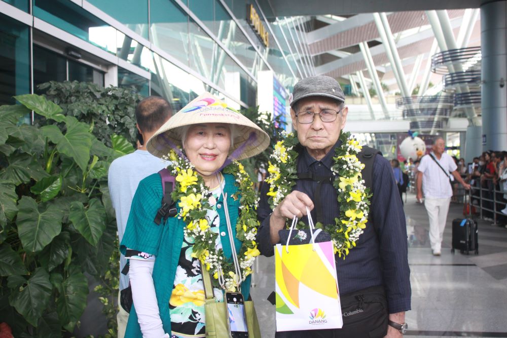 The first 3 lucky passengers to land at Da Nang airport were given fresh flowers, souvenirs and vouchers for round-trip flights to Japan - Vietnam. Photo: Tran Thi