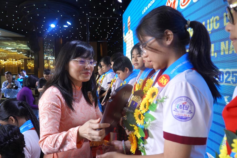 La vice-presidente permanente de la Federation du travail de la province de Dong Nai Bui Thi Bich Thuy remet des certificats de merite aux enfants des CNVCLD des forces armees qui etudient bien et vivent bien en 2025. Photo : Ha Anh Chien