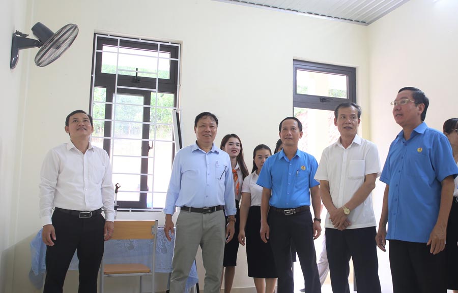 M. Nguyen The Lap (a droite) - President de la Federation du travail de la province de Quang Tri inspecte la maison de fonction des travailleurs. Photo : Hung Tho