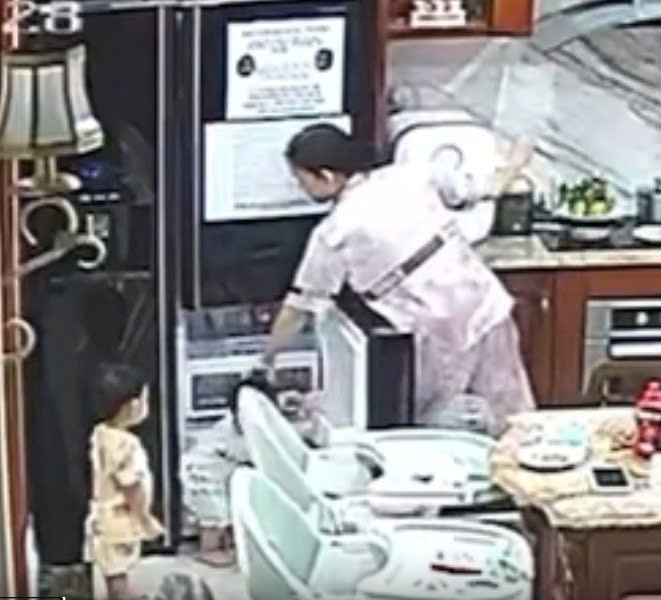 여성은 손으로 냉장고 문을 밀고 아이를 때리는 방식으로 아동을 학대했습니다. 주민들이 제공한 클립에서 캡처한 사진