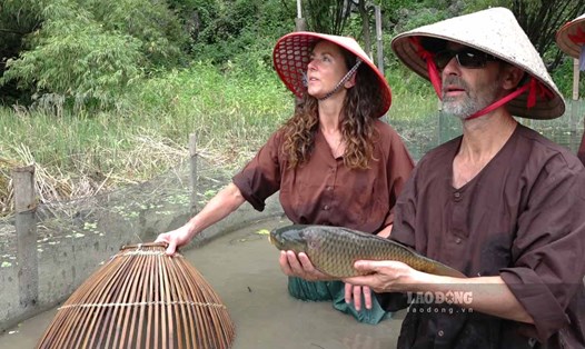 Một du khách thích thú khi trải nghiệm và bắt được cá ở Ninh Bình. Ảnh: Lương Hà