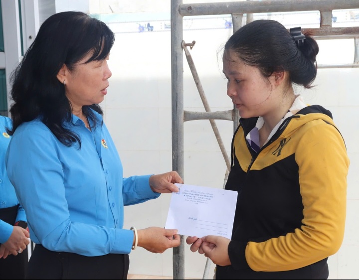 Ba Huynh Thi Tuyet Vui - Chu tich LDLD tinh trao ho tro cho doan vien Le Thi Truc Ly. Anh: Luu Hung. 