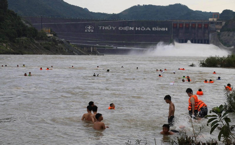 People calmly bathe in the river when Hoa Binh Hydropower Plant releases floodwaters. Photo: Yen San