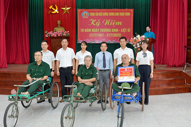 Mai Quoc Long氏 - 党委員会の秘書、取締役会の議長（右から左へ2番目）、およびPPC代表団は、Thuan Thanh War Invalids Nursing Centerの負傷した兵士の代表者に贈り物を贈りました。写真：PHA LAI熱電力