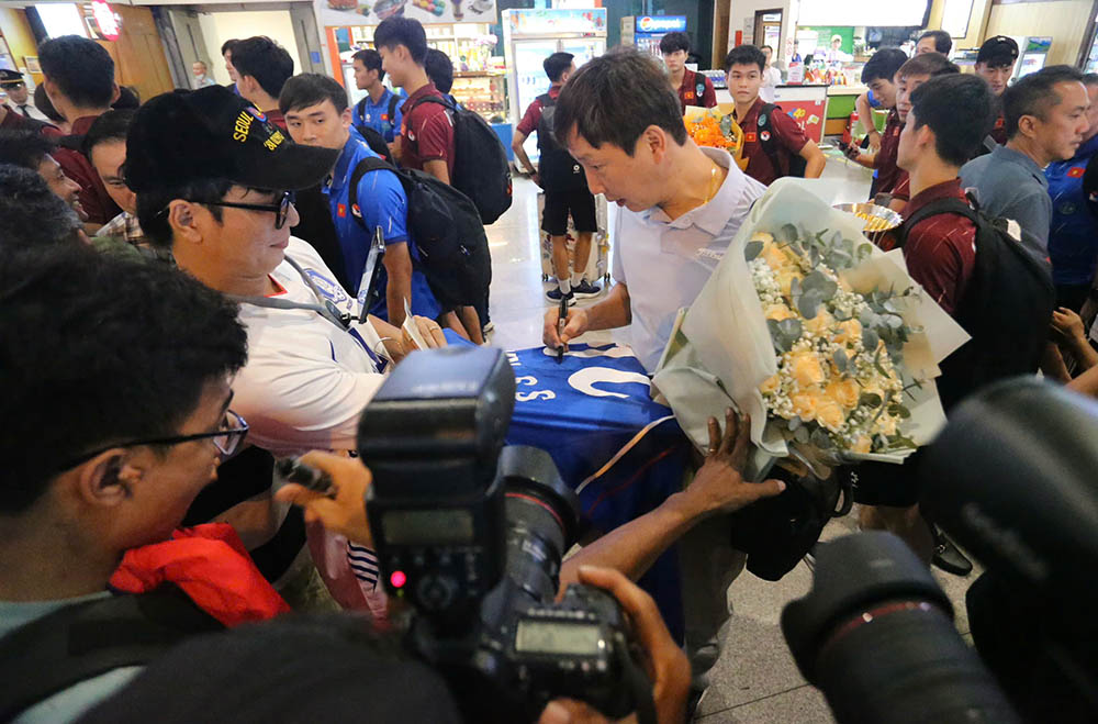 Nhieu co dong vien chuan bi san ao de xin chu ki huan luyen vien Kim Sang-sik va cac cau thu.