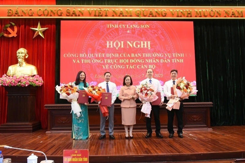 Le secretaire adjoint permanent du Comite provincial du Parti le president du Conseil populaire provincial remet la decision et offre des fleurs pour feliciter les dirigeants nommes. Photo : Minh Khang