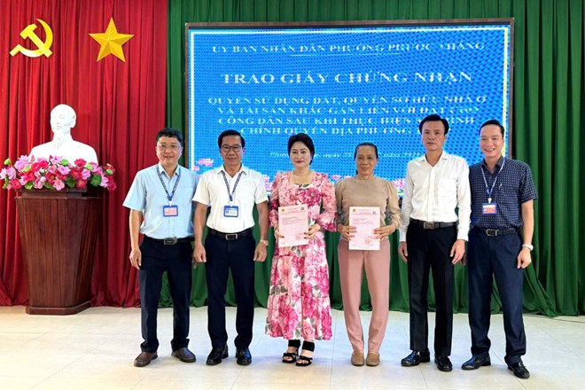 Hai nguoi dan duoc phuong Phuoc Thang ban giao so do chieu 30.7. Anh: Thanh An
