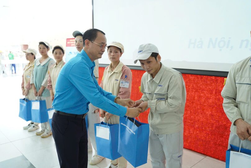 하노이시 베트남 조국전선 위원회 노동조합 업무위원회 부위원장인 Trinh To Tam 씨가 Meiko Vietnam Electronics Co. Ltd.의 노동조합 점심 프로그램에서 조합원과 어려운 노동자에게 지원금을 전달하고 있습니다. 사진: Den Phu