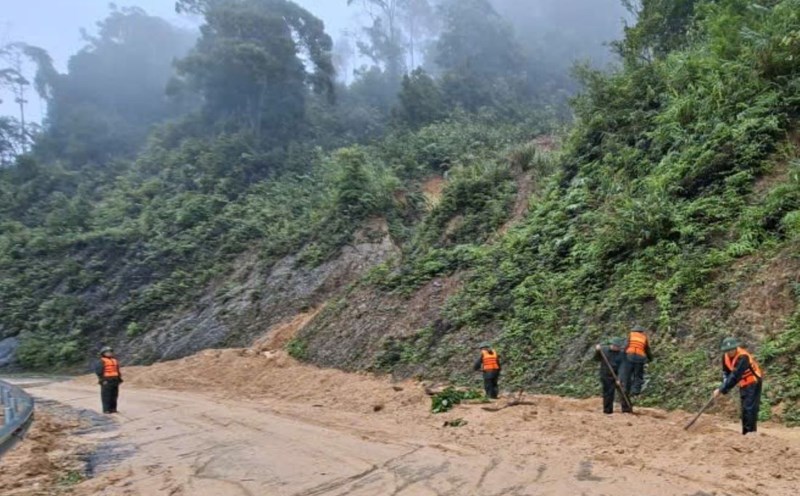 Border guards clear rocks and soil next to the landslide on the Ho Chi Minh Highway West branch. Photo: H.Nguyen