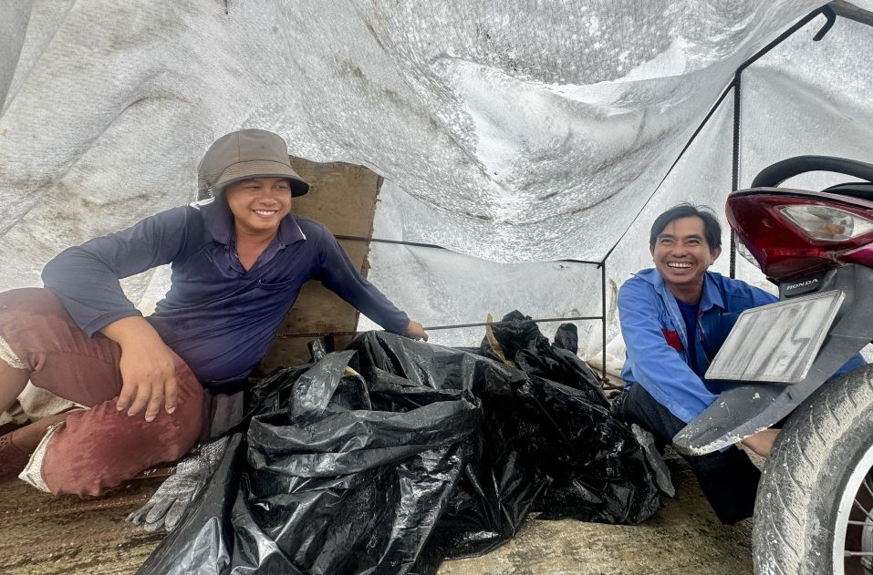Des ouvriers de construction d'autoroute se refugient sous la pluie dans des tentes construites sur le chantier. Photo : Phuong Anh