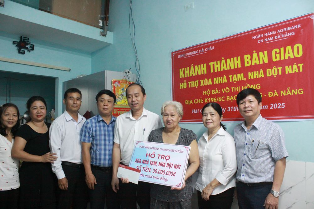 Ms. Vo Thi Hong (on Bach Dang Street) was moved when receiving support to repair her house. Photo: Tran Thi