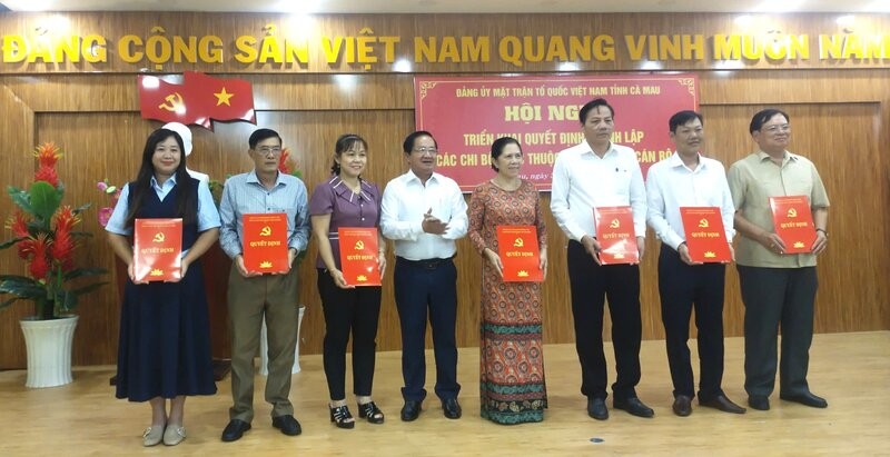 El Vicepresidente Permanente del Comite del Frente de la Patria de Vietnam de la provincia de Ca Mau Le Thanh Trieu entrega la decision de establecer la celula del partido. Foto: Nhat Ho