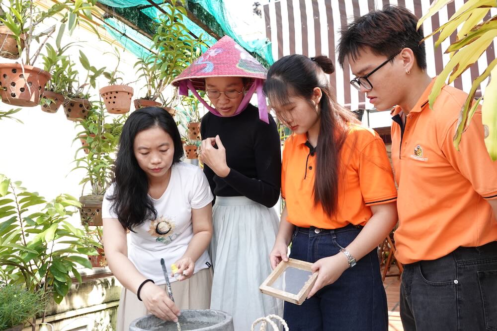 Chi Nga huong dan sinh vien cach lam giay tu bot vo bap. Anh: Han Lam.