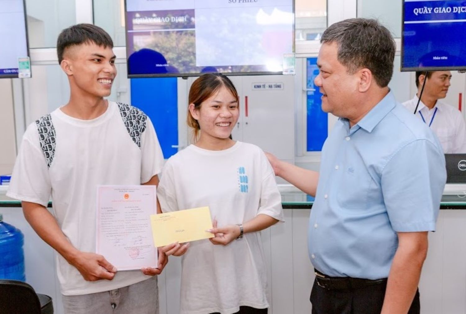 M. Tran Phong - president du Comite populaire de la province de Quang Tri - remet le certificat de mariage et offre des cadeaux de bonheur au premier couple a effectuer les formalites d'enregistrement de mariage lors de l'exploitation de la nouvelle commune. Photo : Hung Tho