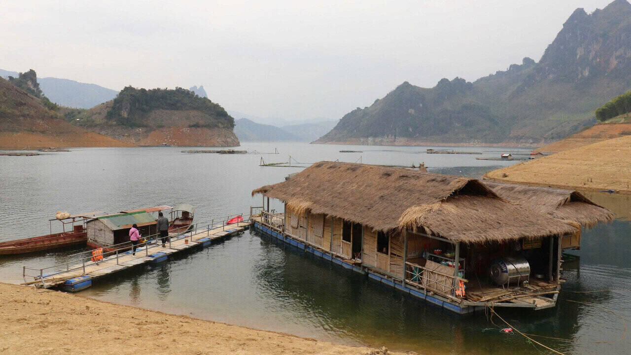 Maisons-batiments et bateaux de peche amarres sur le lac hydroelectrique de Son La l'eau du lac est revenue apres une periode d'epuisement. Photo : Truong Son