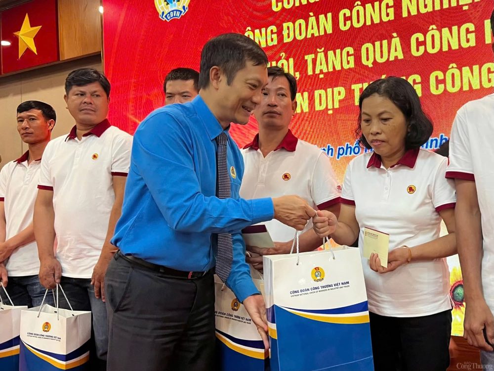 M. Le An Hai - President du Syndicat vietnamien de l'industrie et du commerce offre des cadeaux aux travailleurs en difficulte. Photo : Thuy Linh