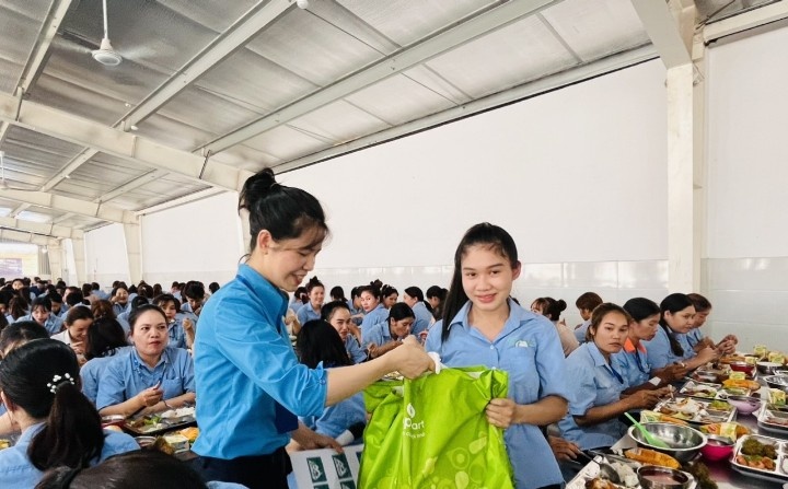 Mme Nguyen Thi Mai Trang - Presidente du syndicat de base de la societe Kanaan Bao Loc Co. Ltd. Zone industrielle de Loc Son province de Lam Dong remet un soutien aux travailleurs lors du repas de travail. Photo : Duc Lam