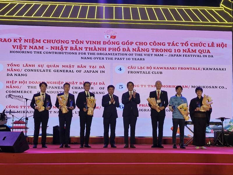 Le president du Comite populaire de la ville de Da Nang Luong Nguyen Minh Triet (au centre) remet une medaille commemorative honorant les contributions a l'organisation du Festival Vietnam-Japon a Da Nang au cours des 10 dernieres annees. Photo : Thu Giang