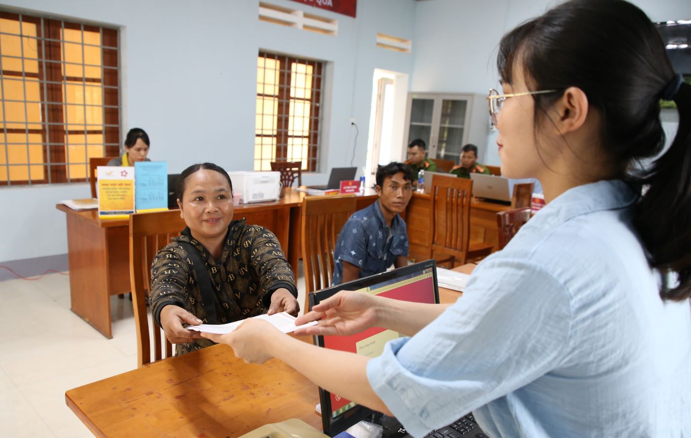 Les fonctionnaires du centre de service administratif public de la nouvelle commune de Dakrong remettent les resultats aux habitants. Photo : Hung Tho